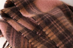 Close-up of pink and brown plaid scarf with soft cashmere-like texture and fringed edges