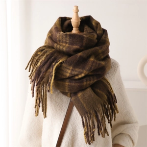 Detailed view of dark brown plaid cashmere scarf with long fringe on a wooden mannequin