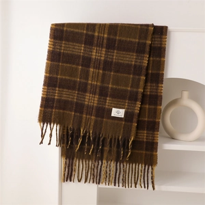 Close-up of vintage brown and mustard plaid scarf with fringe and brand label