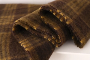 Close-up of thick brushed plaid scarf in brown and mustard yellow with fuzzy texture