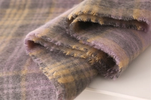 Close-up of thick plaid scarf with purple and yellow fringe and fuzzy wool texture