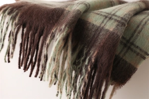 Close-up of brown and mint green checkered scarf with soft brushed texture and tassels