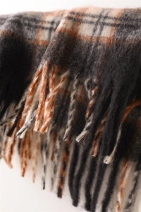 Close-up of checkered cashmere-feel scarf with soft tassels and thick woven texture