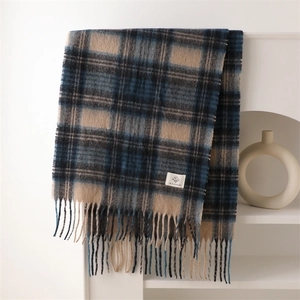 Detailed close-up of heavy checkered scarf texture with fringe and brand label
