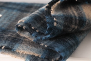 Macro shot of fuzzy blue and beige checkered scarf showing thick soft wool texture