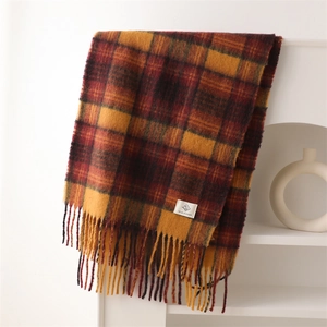 Close-up of British style plaid scarf with soft fringe edges and woven brand label