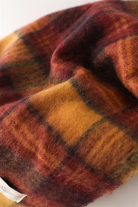 Close-up of warm checkered scarf with soft brushed texture and vintage fringe details