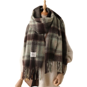 Cozy checkered scarf with fringe details and woven label on beige knit sweater