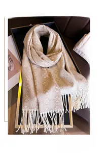 Detailed view of jacquard tassel scarf with floral patterns on a luxury tray