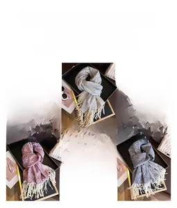 Detail of warm winter scarf with snowflake jacquard pattern and long tassel fringes
