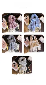 Detail shot of five jacquard knit scarves with snowflake patterns and tassels on a tray