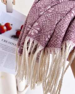 Close-up of jacquard woven scarf with fringes and purple wave pattern on wooden clip