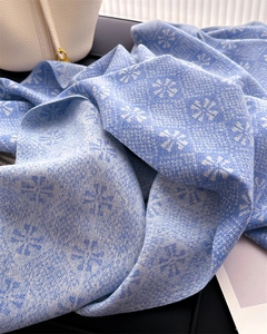 Macro shot of blue cashmere jacquard scarf with white pattern and fringe detail