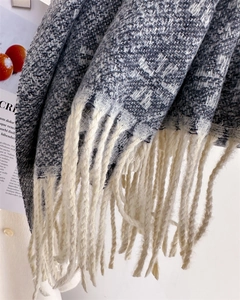 Close-up of blue and white checkered knit scarf with thick yarn and long white tassels