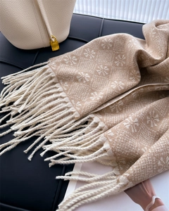 Detail of soft jacquard scarf with snowflake patterns and elegant long fringe tassels