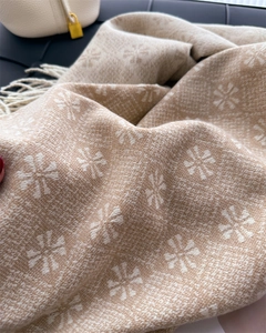 Close-up of soft cashmere-feel jacquard scarf with snowflake patterns and elegant fringes