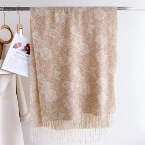 Macro detail of elegant beige cashmere-like scarf with rose jacquard and soft tassels
