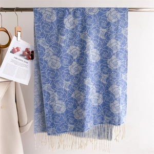 Detail of blue faux cashmere scarf with grey rose patterns and delicate fringe