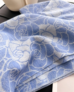 Detail of blue and white knitted scarf showing the soft texture and camellia jacquard pattern