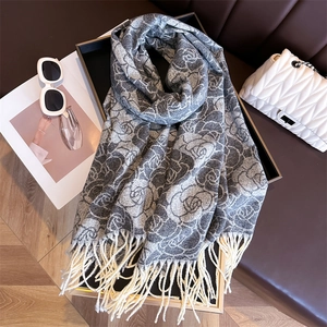 Detail view of grey cashmere-like floral scarf with white roses and soft tassel edges