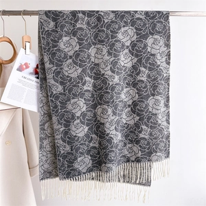 Detail of elegant grey rose floral knit scarf with delicate white fringe tassels