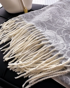 Close-up of gray and white floral jacquard scarf with long tassels and premium texture