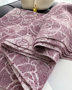 Detail of purple and white floral jacquard knit scarf with elegant rose pattern texture