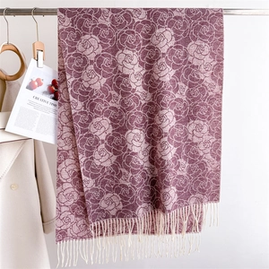 Detail of floral cashmere-like scarf with elegant rose patterns and white fringe tassels
