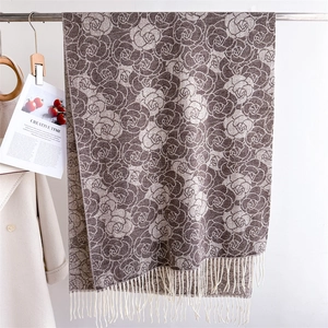 Detail of floral cashmere-like scarf with artistic rose patterns and white fringe tassels