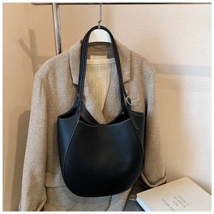 Dettaglio della borsa tote in pelle nera con cuciture bianche a contrasto e fibbie