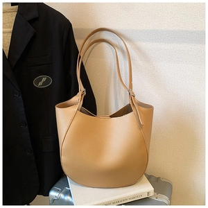 Dettaglio borsa a spalla marrone chiaro in ecopelle martellata dal design curvo elegante