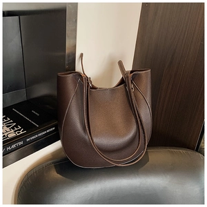 Dettaglio della borsa tote in pelle marrone scuro con cuciture bianche a contrasto
