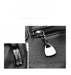 Détail d'un sac à main en cuir noir avec fermetures éclair et doubles compartiments