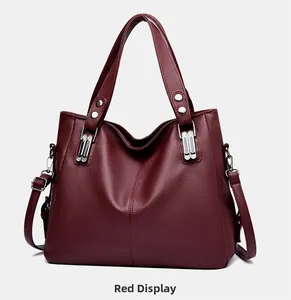 Vue détaillée du cuir rouge vin à motif litchi et des rivets argentés sur le sac