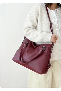 Sac fourre-tout en similicuir bordeaux porté par un mannequin avec bandoulière réglable
