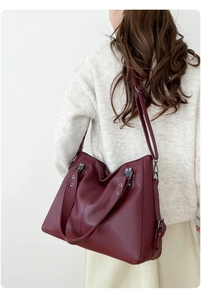 Vue latérale du sac fourre-tout bordeaux avec texture litchi et bandoulière réglable