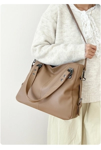 Vue détaillée du sac à bandoulière en cuir grainé marron porté par un mannequin