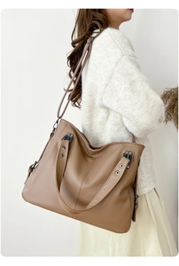 Détail d'un grand sac cabas marron avec texture litchi et rivets sur le côté