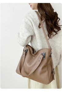 Détail du sac cabas en cuir grainé marron avec bandoulière et finitions métalliques