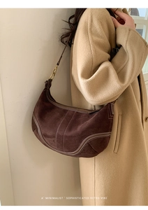 Détail du sac à bandoulière rétro en daim marron foncé avec coutures contrastées et or