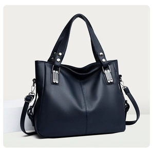 Détails du sac cabas bleu marine avec texture cuir, rivets et couture précise