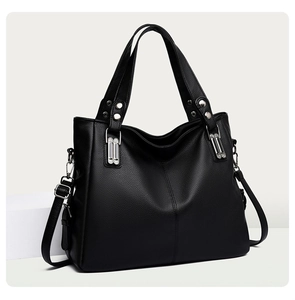 Détails d'un sac cabas noir en cuir grainé avec des clous et des ferrures en métal argenté