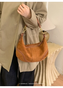 Détail du sac hobo rétro en daim fauve avec surpiqûres et anneaux métalliques dorés