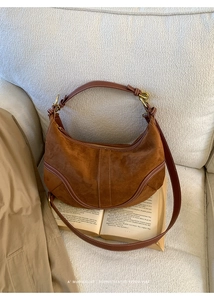 Détail d'un sac hobo vintage marron avec surpiqûres contrastées sur un tissu doux