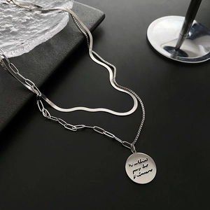 Double-layered silver necklace with flat snake chain and a round letter pendant charm