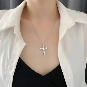 Silver cross pendant necklace with sparkling cubic zirconia on a female model
