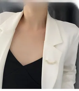Gros plan d'une broche sourire dorée avec zircons épinglée sur le revers d'un blazer