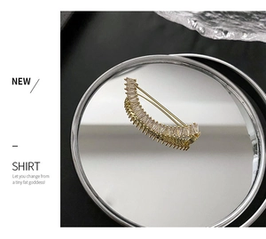 Détail d'une broche croissant avec cristaux rectangulaires sur miroir réfléchissant