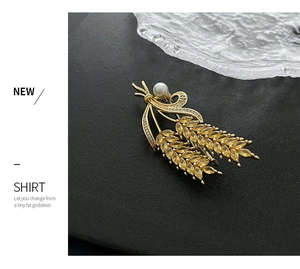Détail de la broche épi de blé dorée avec cristaux jaunes et perle blanche élégante