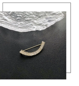 Détail macro d'une broche en croissant de lune avec zircons et dorure à l'or